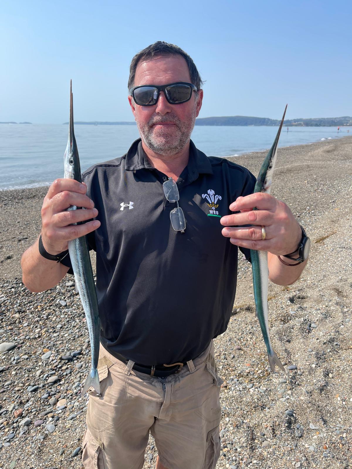 Tony Owen on a North Wales rock mark holding a fishing rod